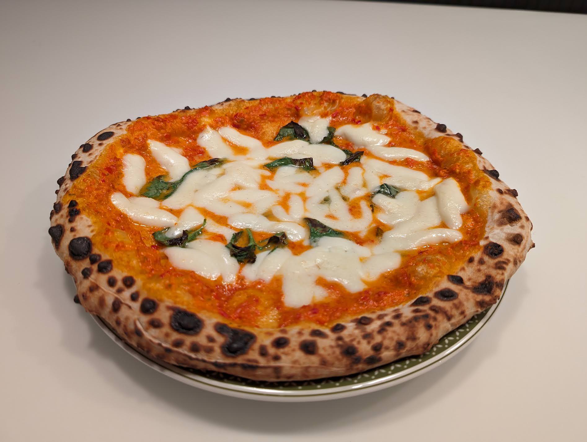 Neapolitan pizza with a leopard-spotted cornicione fresh from a wood-fired oven